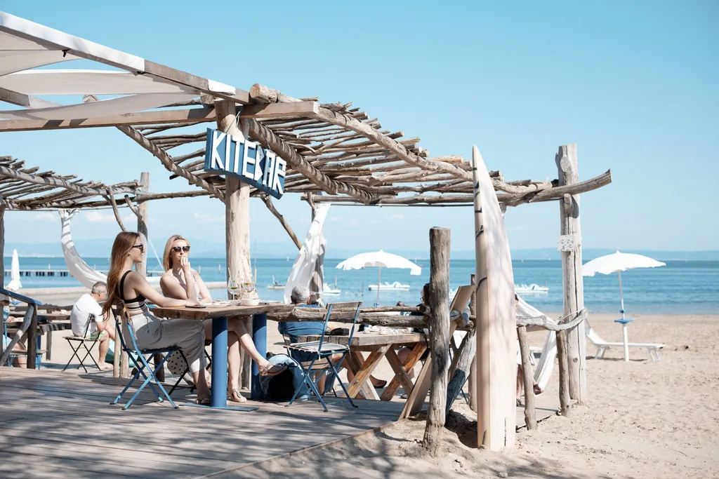 Zwei Frauen sitzen in der Kitebar direkt am Strand mit Blick auf das Meer in unmittelbarer Nähe des Tenuta Primero Grado Family Collection