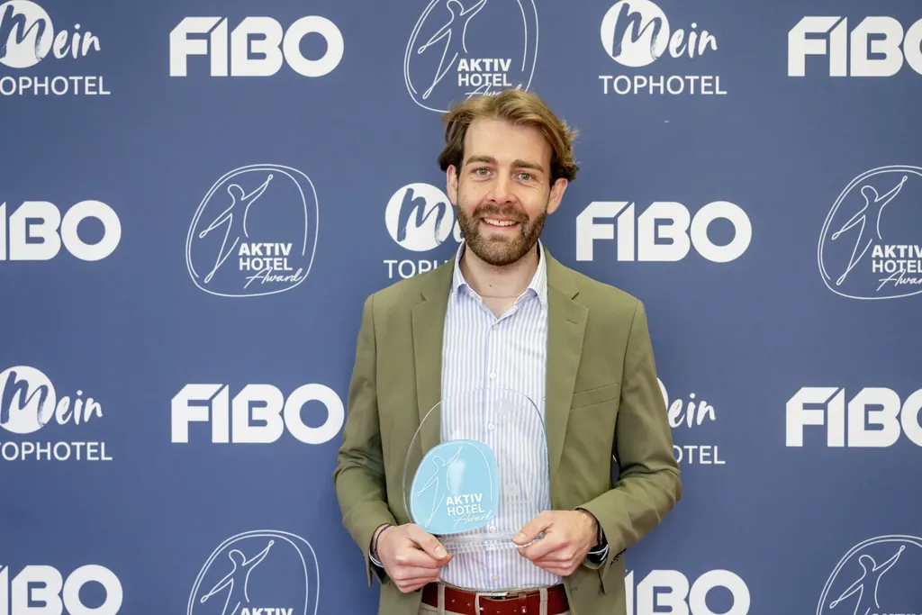 Severin Mühlberger vom Peternhof hält den Aktiv Hotel Award 2025 in der Hand