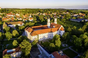 Luftaufnahme des Kloster Irsee mit Blick auf umliegenden Wald und Häuser