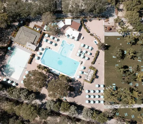 Luftaufnahme der Poolanlage des Tenuta Primero Grado Family Collection mit zwei großen Pools, Sonnenliegen und Sonnenschirmen