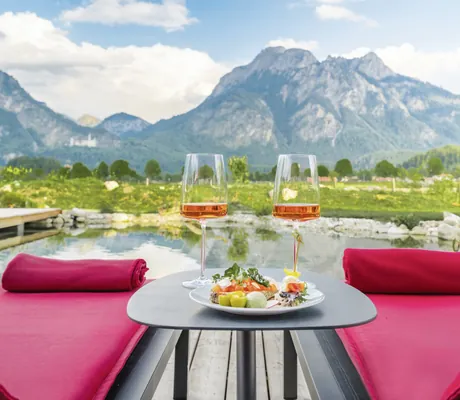 rot gepolsterte Liegen und Tisch mit zwei roséfarbenen Getränken im Das Rübezahl am Naturbadeteich