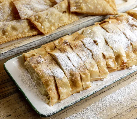 Apfelstrudelstücke auf einer weißen Kuchenplatte im Das Parkhotel