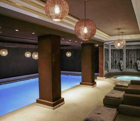 Indoorpool im Das Parkhotel mit runden Korbleuchten und Whirlpool mit Schwarz/Weiß-Wänden