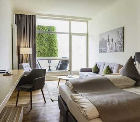 Blick vom Doppelbett im Das Parkhotel auf Balkon und Park