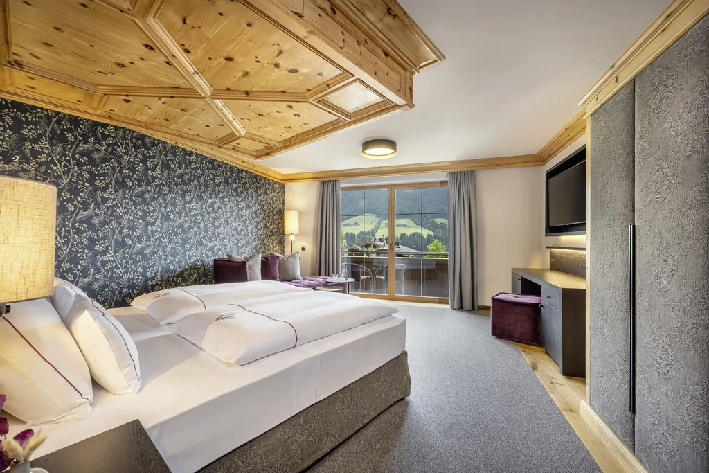 Doppelzimmer im Der Böglerhof – pure nature spa resort mit dunkelgrauer Blumentapete und Blick nach außen