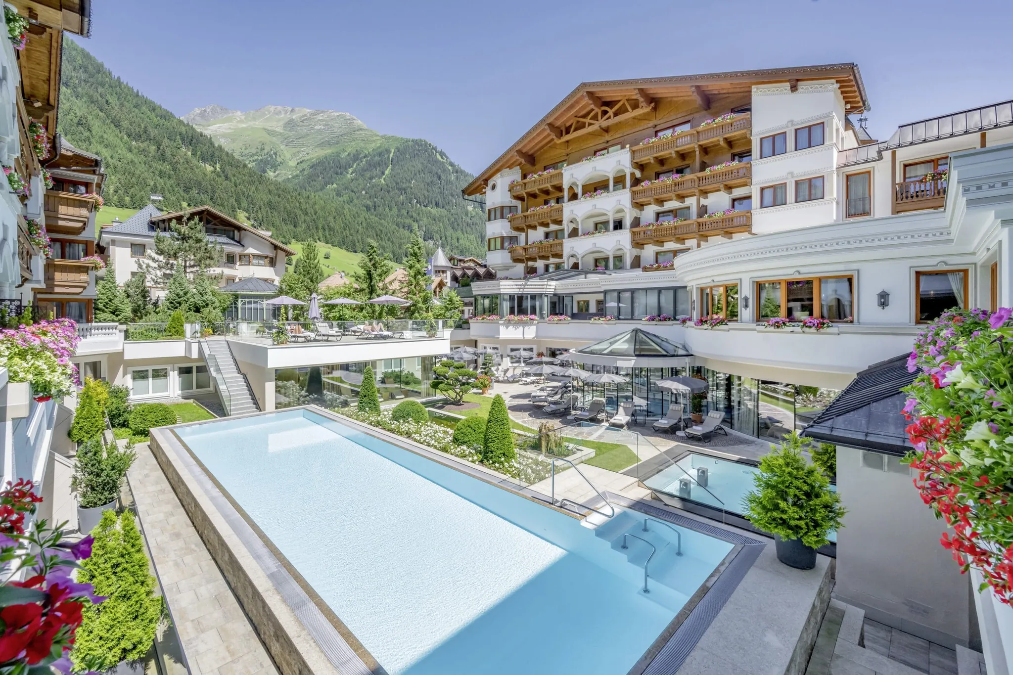 Außenansicht des Trofana Royal Resort im Sommer mit Outdoorpool im Vordergrund