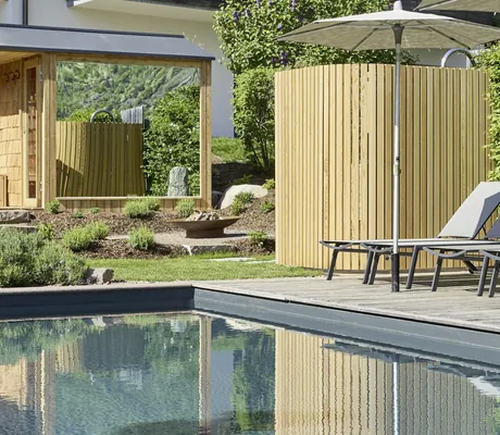 Nahaufnahme des Outdoorpools der Cirna Gentle Luxury Lodges mit Außendusche und verspiegelter Außensauna im Hintergrund