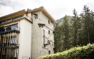 Blick auf die Fassade des Excelsior Dolomites Life Resort mit Kletterwand