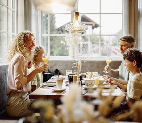 Familie sitzt am gedeckten Frühstückstisch im RESL Resort