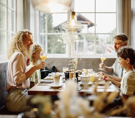 Familie sitzt am gedeckten Frühstückstisch im Resl Resort