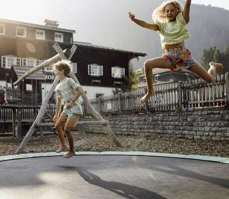Junge und Mädchen hüpfen auf dem Outdoor-Trampolin des RESL Resort