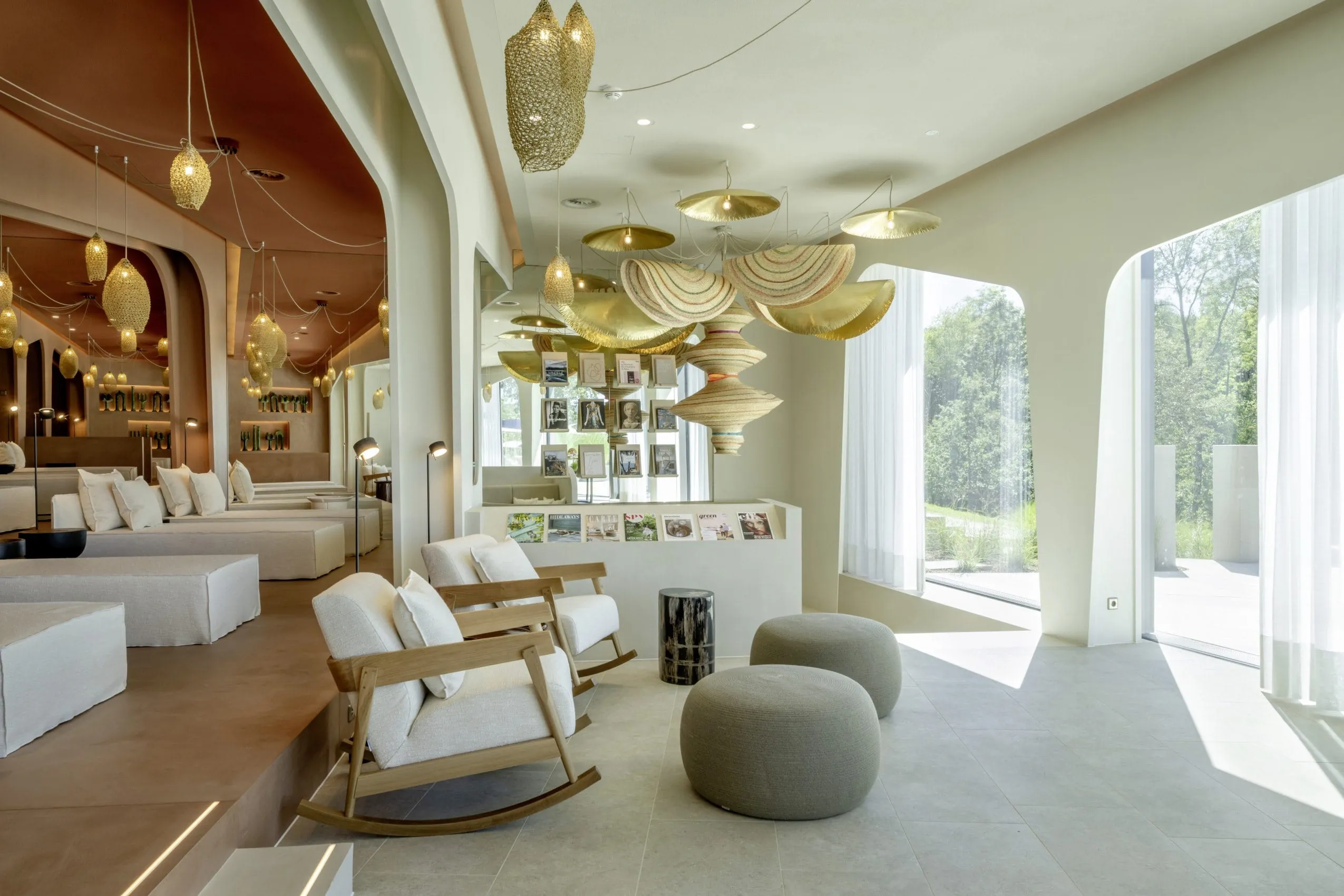 Moderner Spa-Bereich mit Designer-H&auml;ngeleuchten, wei&szlig;en Loungem&ouml;beln und goldenen Dekor-Elementen im Naturhotel Seezeitlodge