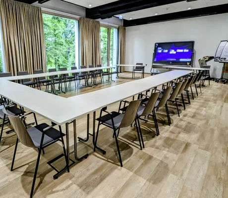 Tagungsraum mit U-Bestuhlung im Parkhotel Schillerhain mit großen Glasfronten und Blick in den Park