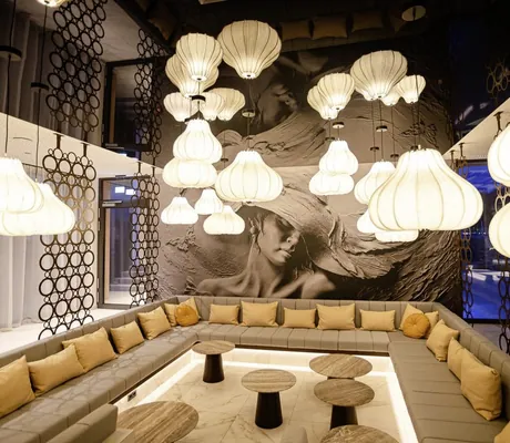 Wellnesslonge im Das König Ludwig Inspiration SPA mit weißen Ballonlampen und großem schwarz/weiß-Bild als Hintergrund