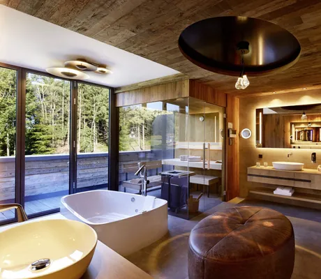 Modernes Bad in der Private Sky Suite des Wellness- und Naturresort Reischlhof mit Finnischer Sauna, Whirlpool-Badewanne und Regendusche