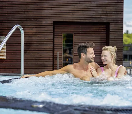 Paar sitzt im Outdoor-Whirlpool des Wellness- und Naturresort Reischlhof
