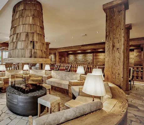 Gemütlicher Lounge- und Wellnessbereich mit Kamin, Holzdekor und bequemen Sitzmöglichkeiten in rustikalem Ambiente im Wellness & Naturhotel Tonihof****S