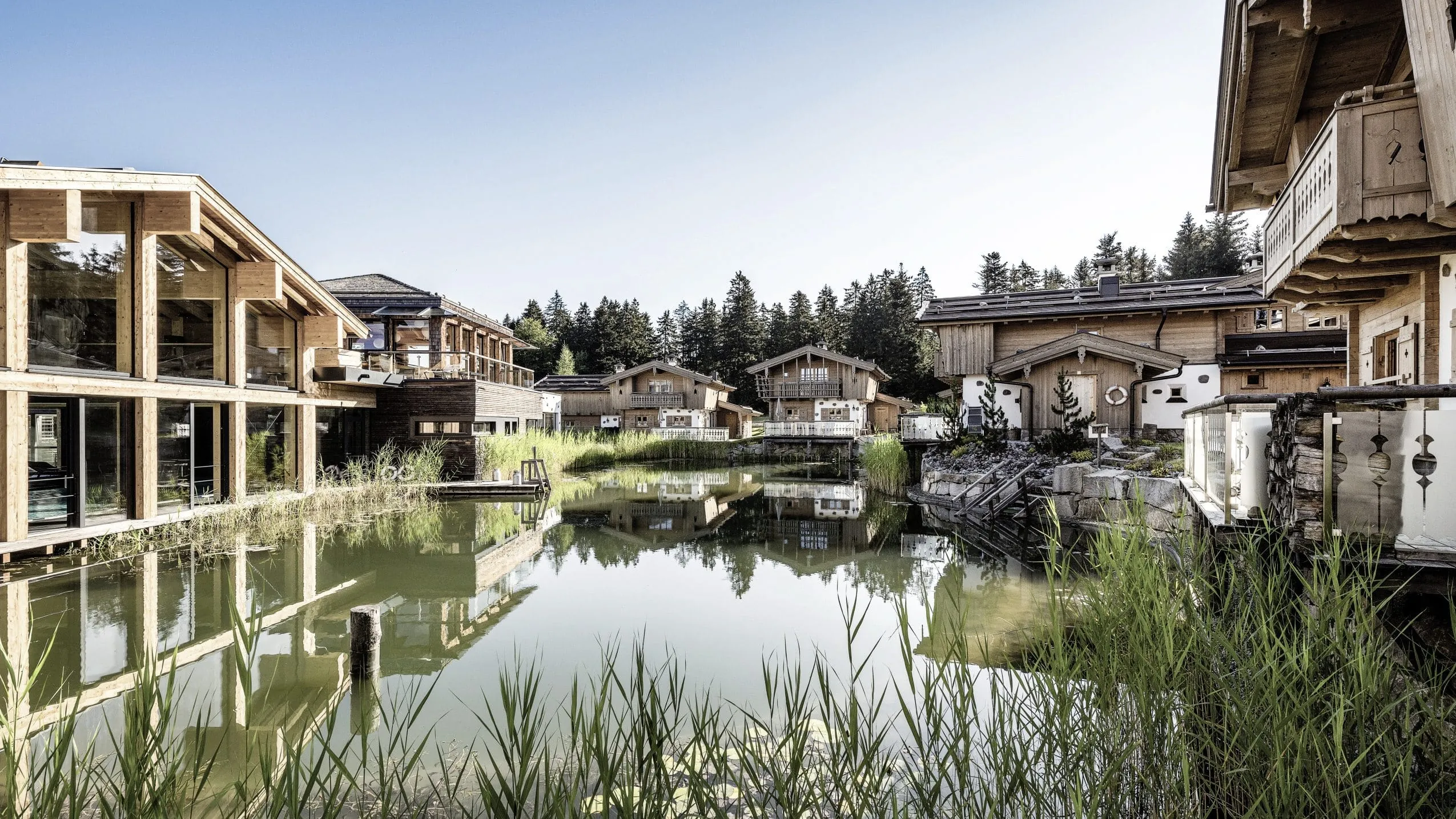 Blick auf die Chalets mit Naturbadeteich des INNs HOLZ Chaletdorf