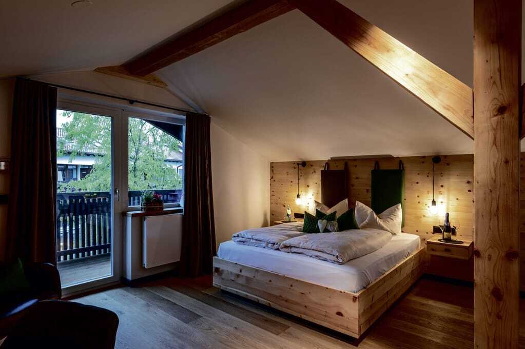 Doppelzimmer unter Holzbalken mit Balkon im Hotel Alpenblick Ohlstadt