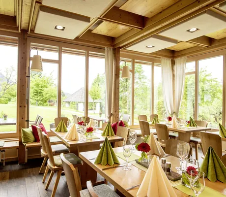 mit grünen und beigen Servietten eingedeckte Tische im Restaurant des Hotel Alpenblick Ohlstadt