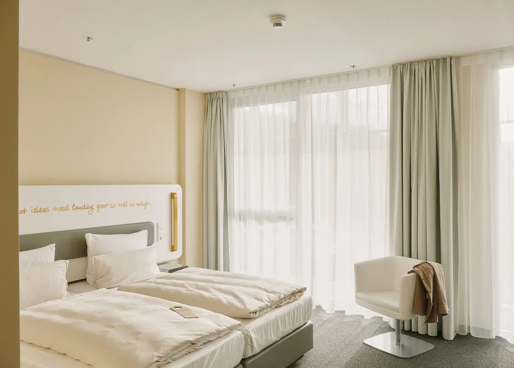 sehr helles Doppelzimmer mit Spruch auf Bettkopf im Lufthansa Seeheim