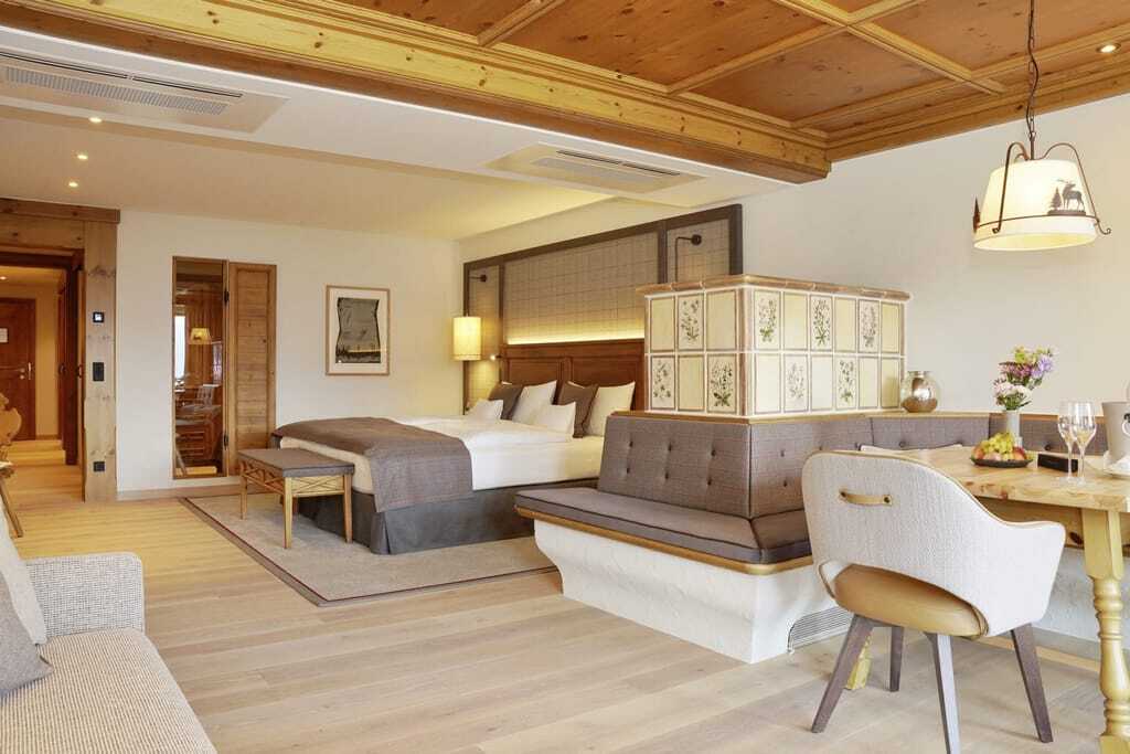 großes Doppelzimmer im Interalpen-Hotel Tyrol mit Kachelofen und eingedecktem Bauerntisch