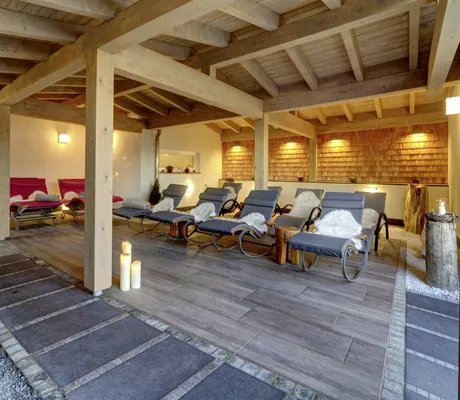Outdoor-Ruhebereich des Wellnesshotel Hofbräuhaus mit Liegestühlen mit Fellen, Kerzen und Holzdecke