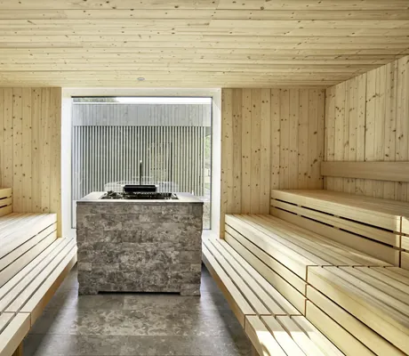 Große, helle Sauna mit Aufgussstelle in der Mitte im "QuellenReich SPA" des Hotel Winkler Bräu