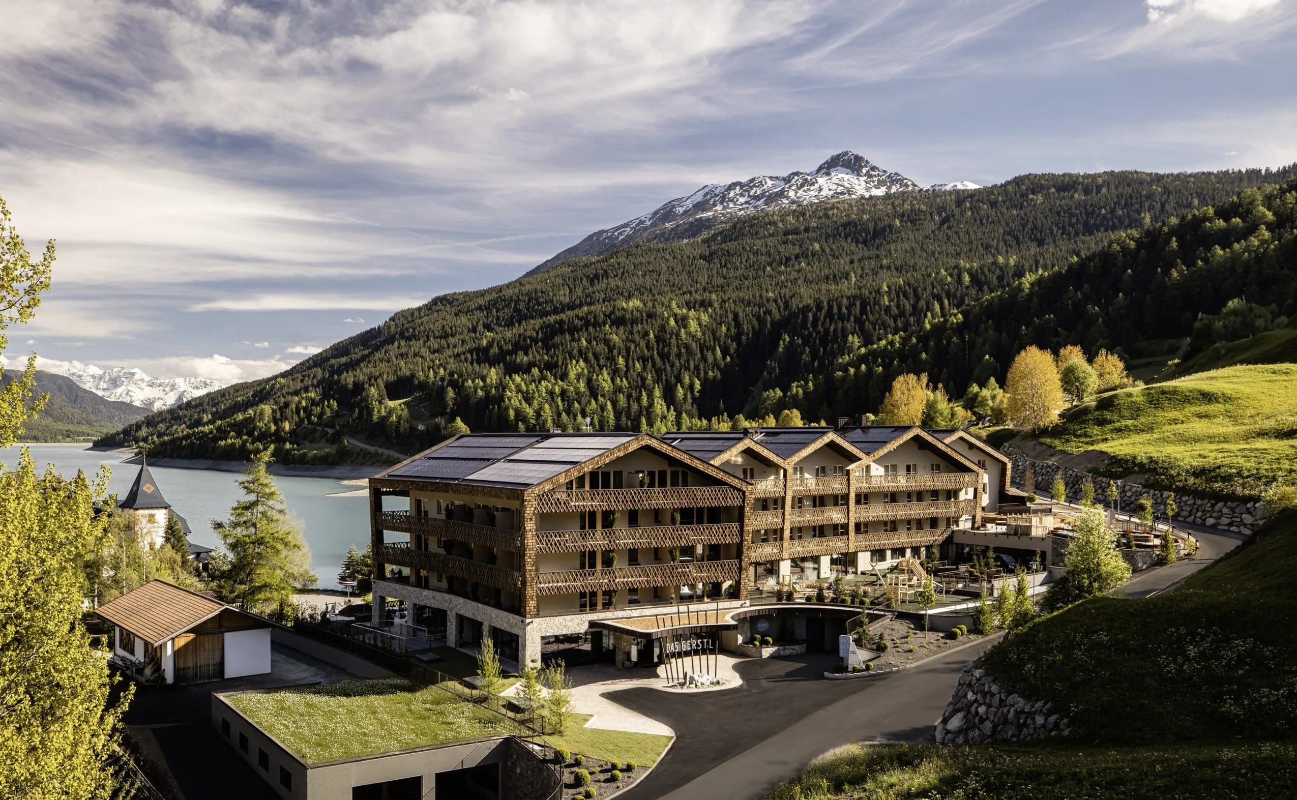 Außenansicht des DAS GERSTL Family Resort mit Blick auf den Reschensee