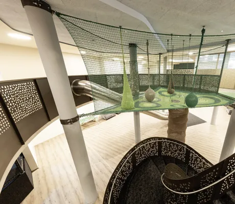 Nest und Rutsche in luftiger Höhe über der Treppe im DAS GERSTL Family Resort