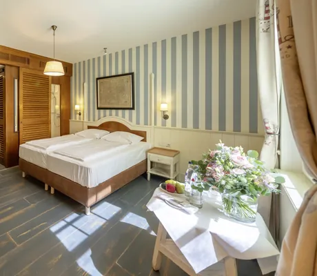 Familienzimmer im Bell Rock mit Doppelbett, Holzmöbeln, Streifenwand und Blumendekoration