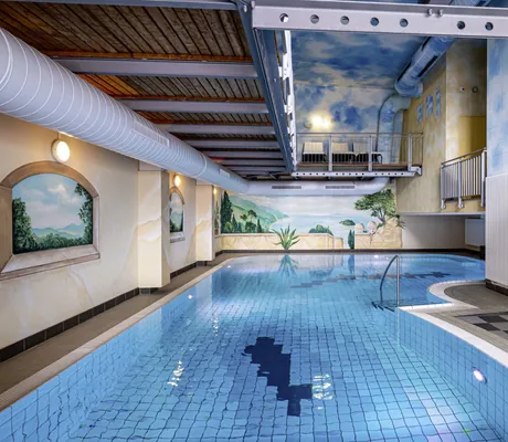 Indoorpool im Wellnesshotel Randsbergerhof mit bemalten Wänden und Fliesenboden