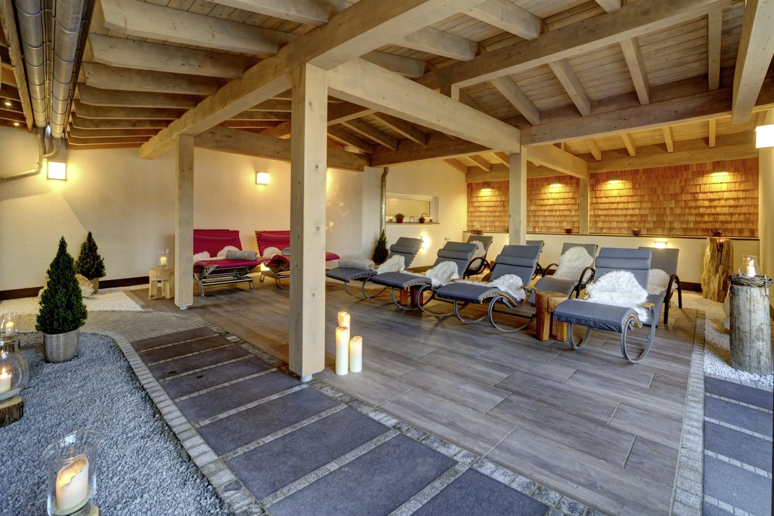 Outdoor-Ruhebereich des Wellnesshotel Hofbr&auml;uhaus mit Liegest&uuml;hlen mit Fellen, Kerzen und Holzdecke
