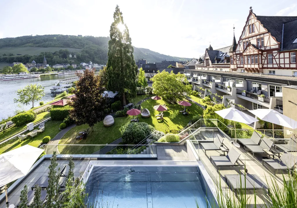 Fassade und Outdoorpool des Moselschlösschen Spa & Resort mit Blick auf die Mosel