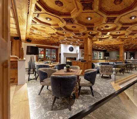 Loungebereich im Trofana Royal Resort mit Holzbalkendecke, Sesseln und Tischen auf gemustertem Boden