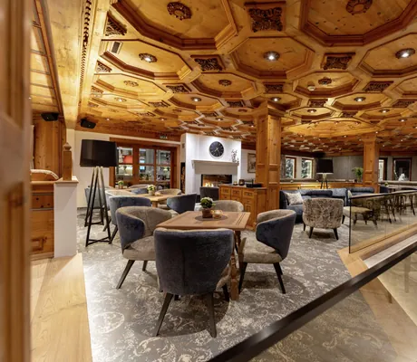 Loungebereich im Trofana Royal Resort mit Holzbalkendecke, Sesseln und Tischen auf gemustertem Boden