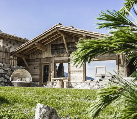 Blick vom Garten aus auf die Terrasse des Chalets mit Liegemuschel im Chalet Resort ZU KIRCHWIES