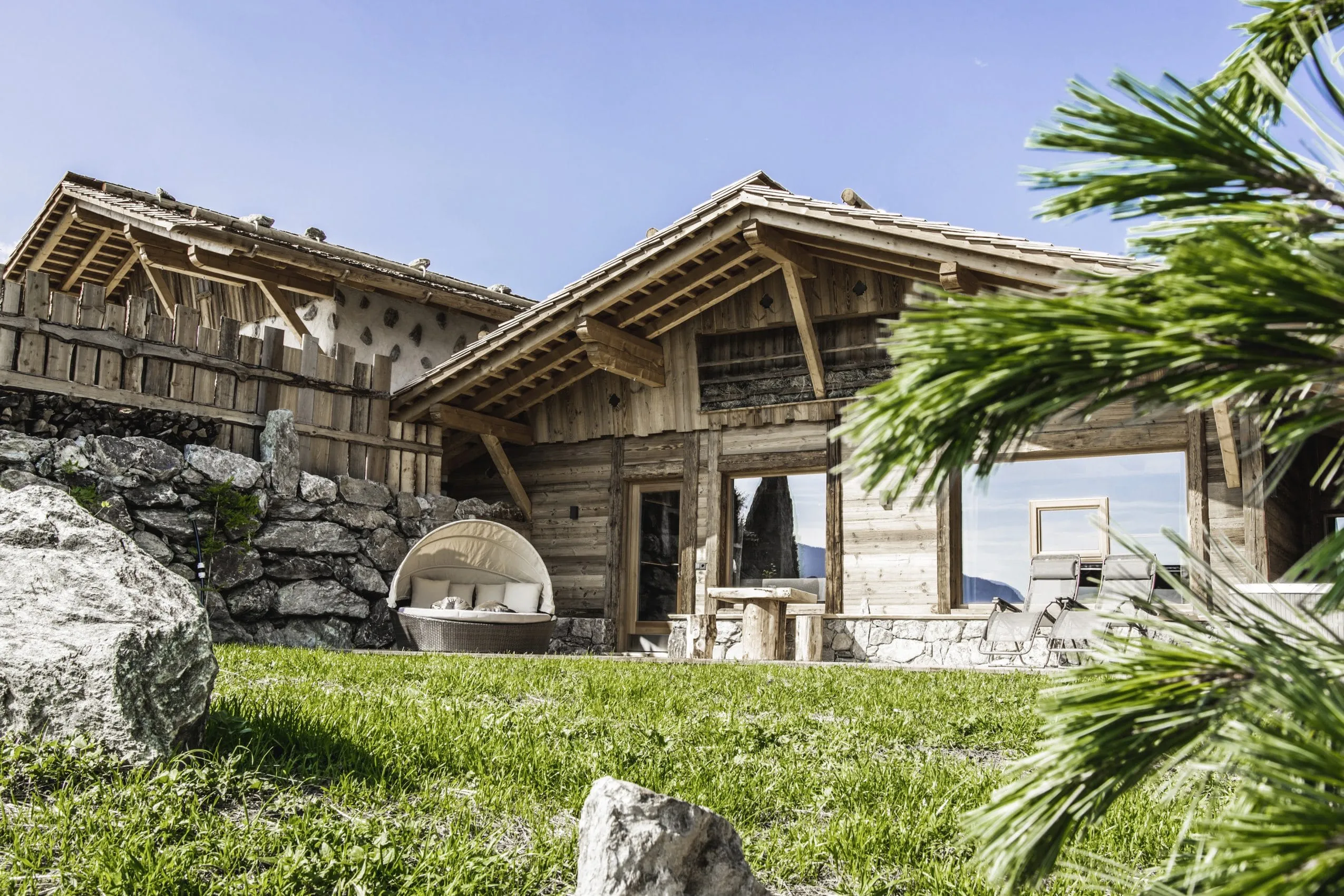 Blick vom Garten aus auf die Terrasse des Chalets mit Liegemuschel im Chalet Resort ZU KIRCHWIES
