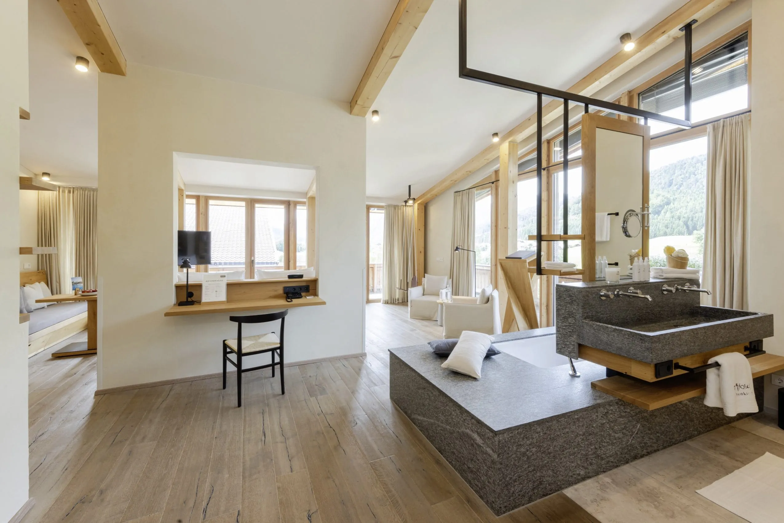 gro&szlig;e Suite im Posthotel Achenkirch mit offenem Bad mit Granitbadewanne und Granitwaschbecken