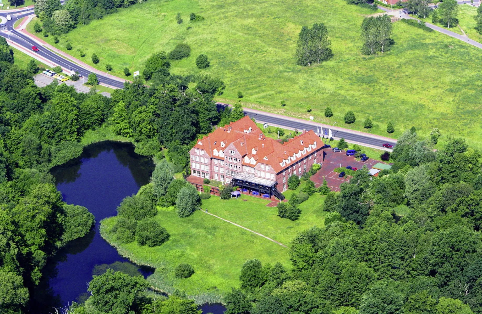 Luftaufnahme des Parkhotel Fasanerie am See inmitten von Wiesen und Wäldern