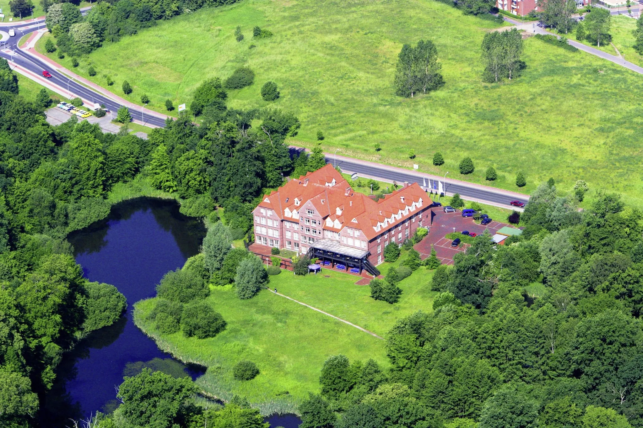 Luftaufnahme des Parkhotel Fasanerie am See inmitten von Wiesen und Wäldern