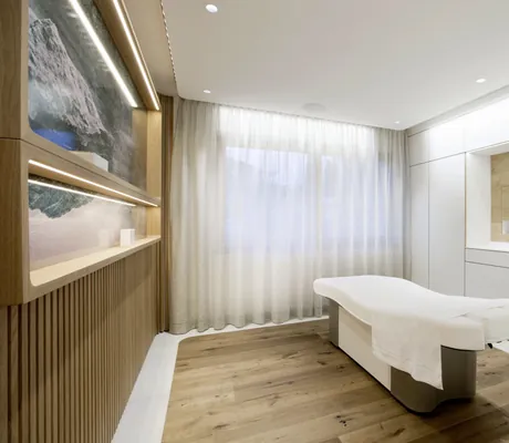 schlichter eleganter Behandlungsraum im Alpenresort Schwarz mit beleuchteten Bildern