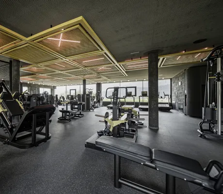 riesiger Fitnessraum im Bliss House des Alpenresort Schwarz mit Leuchtelementen an der Decke