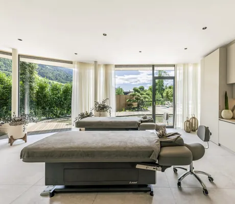 großer Behandlungsraum mit zwei Kosmetikliegen und grauen Handtüchern im Das Alpenschlössel