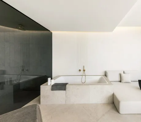 große helle Badewanne im Private Spa des Das Alpenschlössel mit weißer Ruheliege