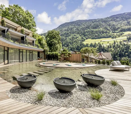 große graue runde Wasserelemente im Naturteich des Das Alpenschlössel vor der Yogaplattform im See