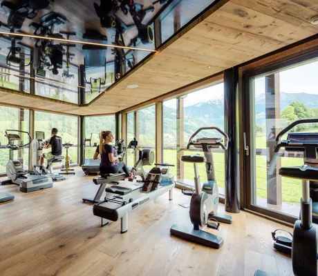 blonde Frau mit Zopf auf dem Rudergerät im Fitnessraum des Andreus Resort