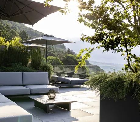 Lounge-Sitzecke mit beigen Polstern auf der Terrasse des Avidea