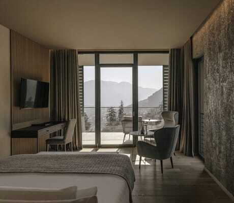Blick ins Zimmer des Avidea mit Blick vom Bett auf die Baumwipfel