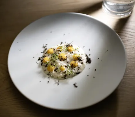 Wachtelei-Gericht auf weißem Teller auf Holztisch im Das Gerstl Alpine Retreat